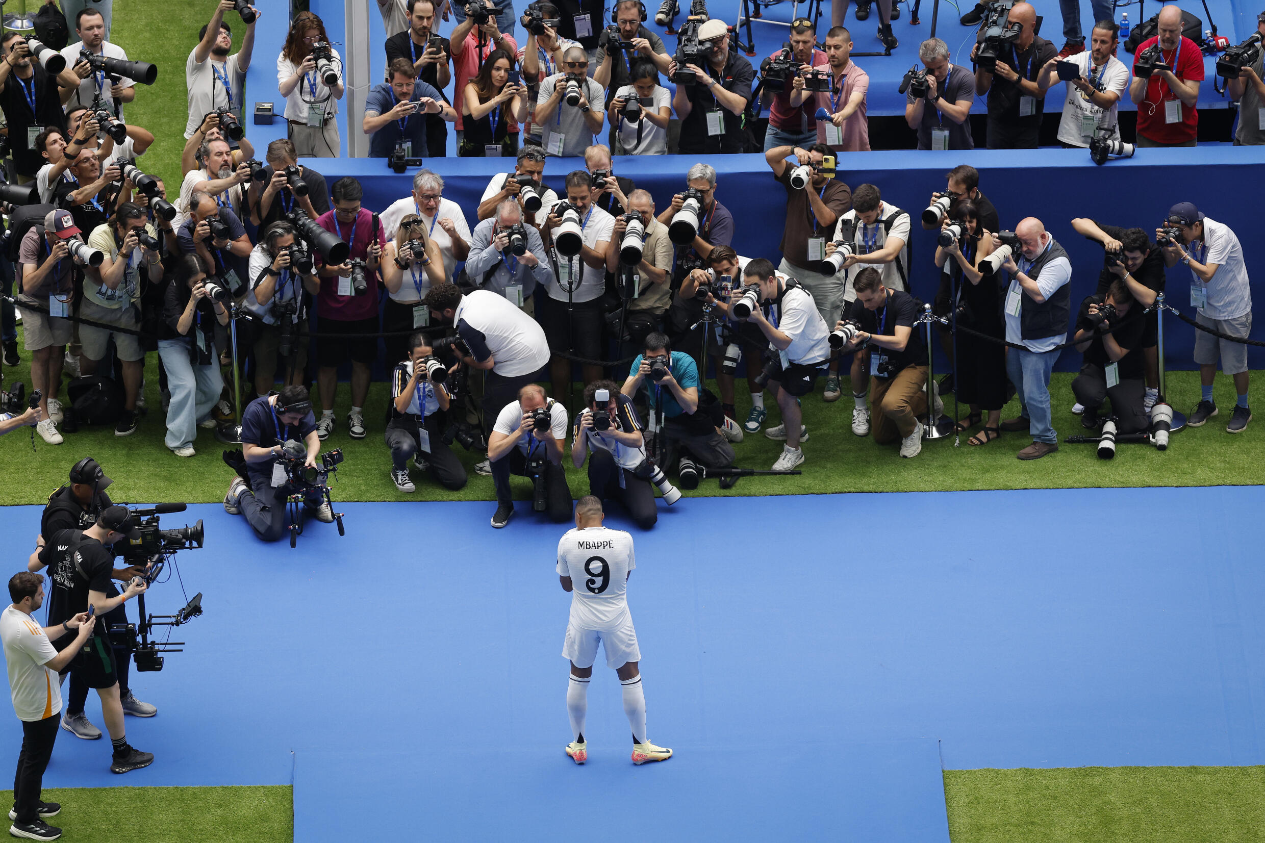 Kylian Mbappe poses for photos during his first appearance as a Real Madrid player at Santiago Bernabeu stadium