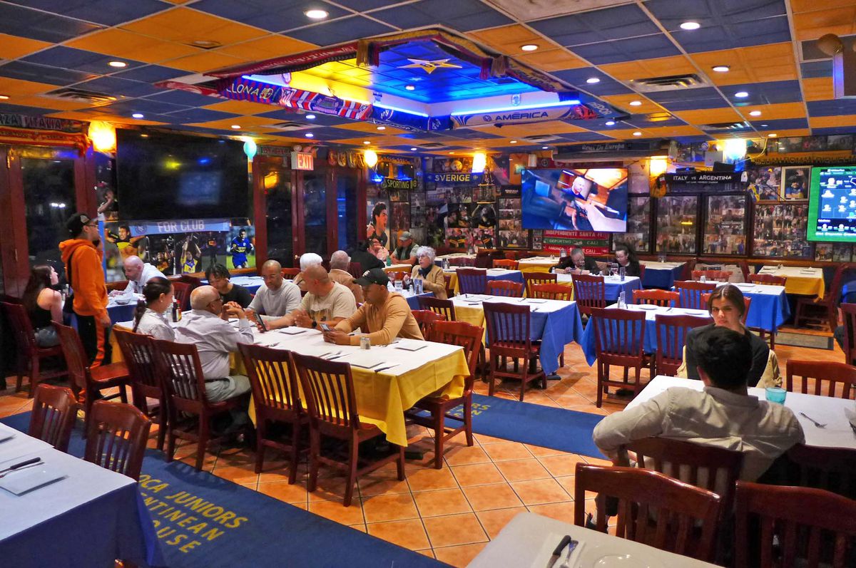 A room with giant tables and TV screens on the walls.