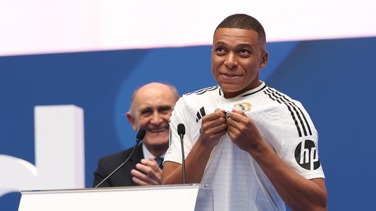 French forward Kylian Mbappe (R) greets fans next to the honorary president of Real Madrid Jose Martinez Pirri during his first appearance as a Real Madrid player at the Santiago Bernabeu Stadium in Madrid(AFP)