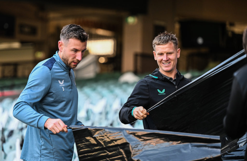 Paul Dummett of Newcastle United FC (L) and teammate Matt Ritchie (R) help lay out flags in preparation for the Global Football Week Match between ...