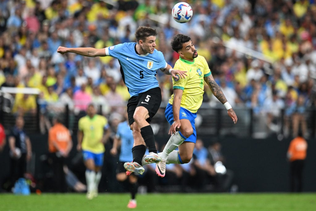 Manuel Ugarte of Uruguay and Lucas Paqueta of Brazil jump for the ball during the CONMEBOL Copa America 2024 quarterfinal match between Uruguay and...