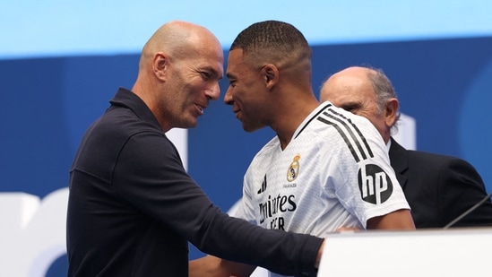 Kylian Mbappe (C) is congratulated by French icon Zinedine Zidane (L) during his first appearance as a Real Madrid player at the Santiago Bernabeu(AFP)